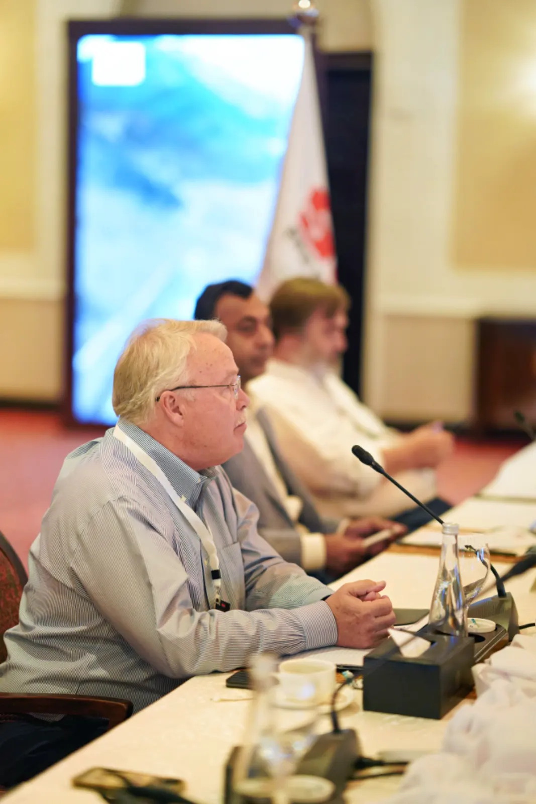 An international delegate follows the discussion at the conference table.