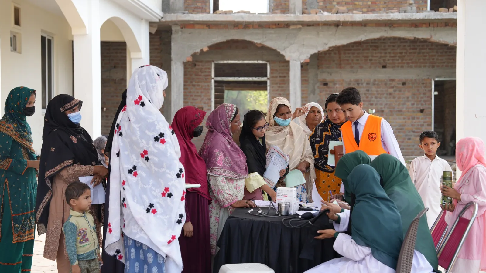 Women and children gather at a registration table as they arrive at the camp.