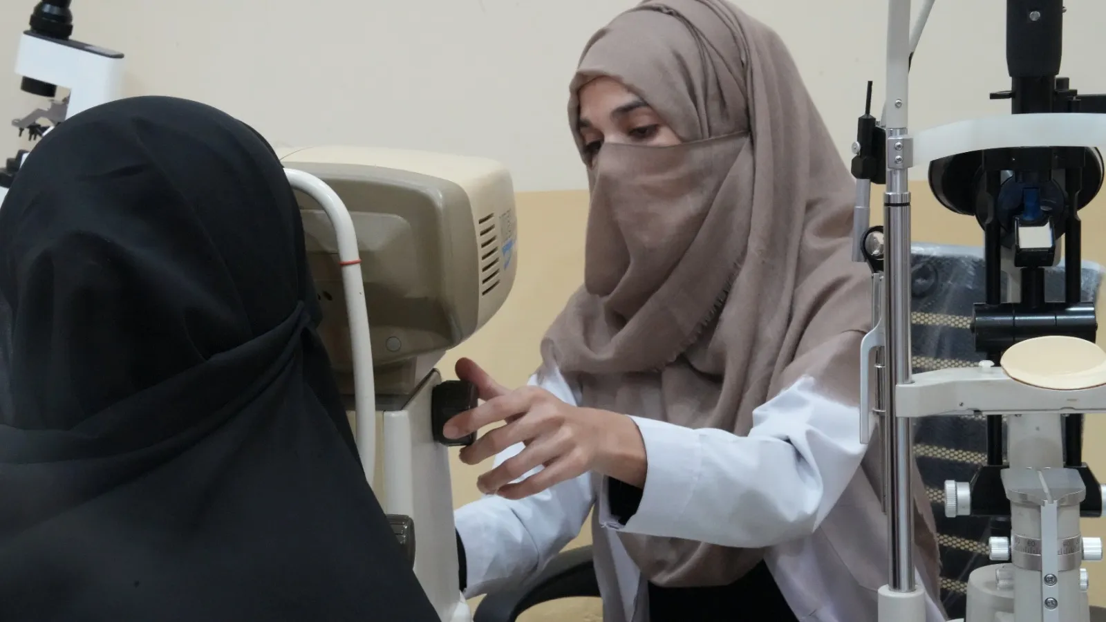 An optometrist examines a patient’s eyes at a slit-lamp.