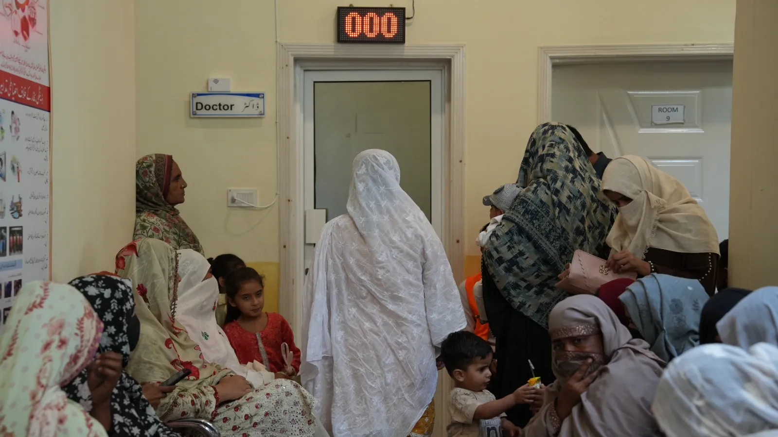 Women and children wait outside a doctor’s room.