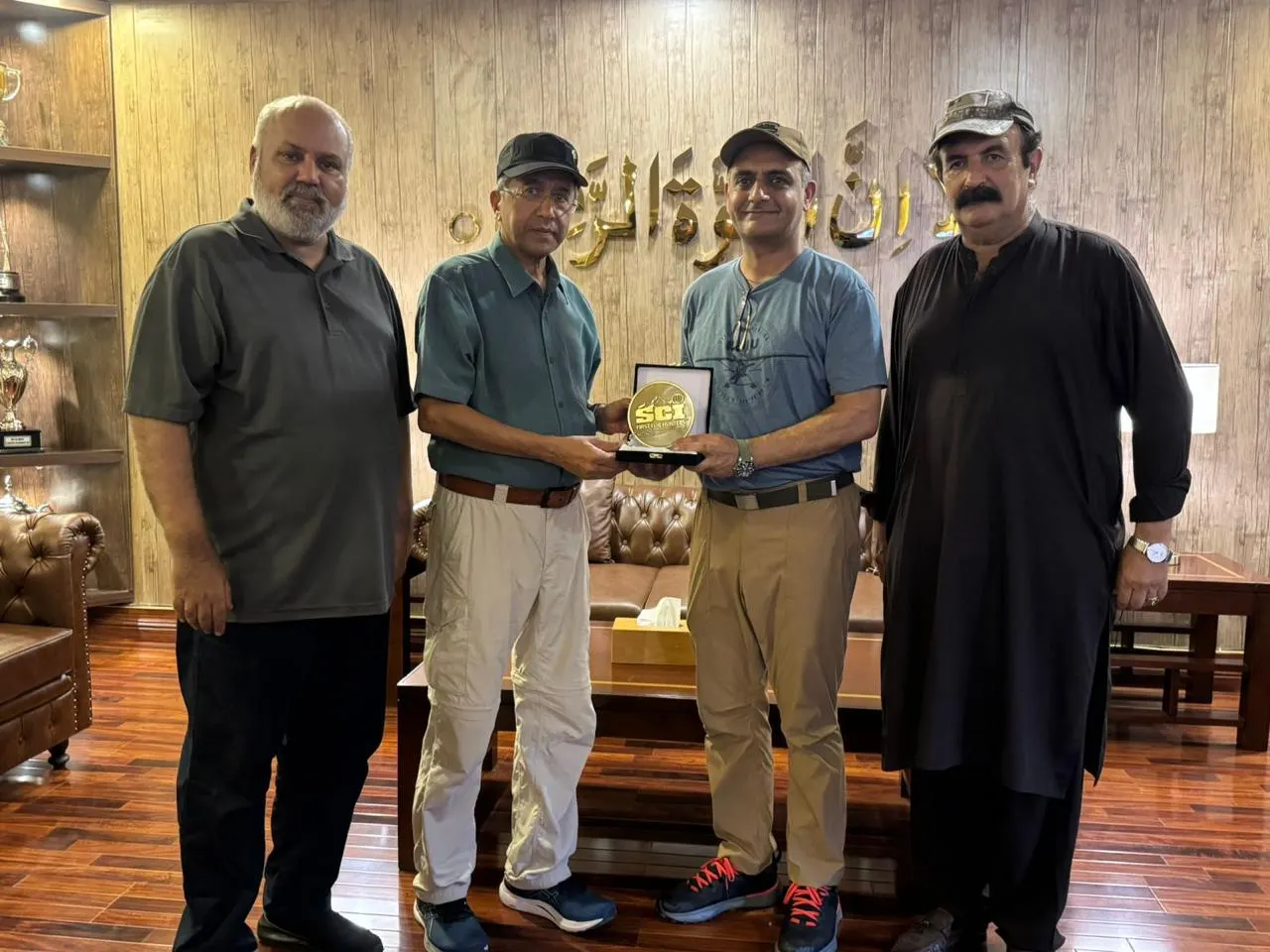 Members present a shield inside the range clubhouse.